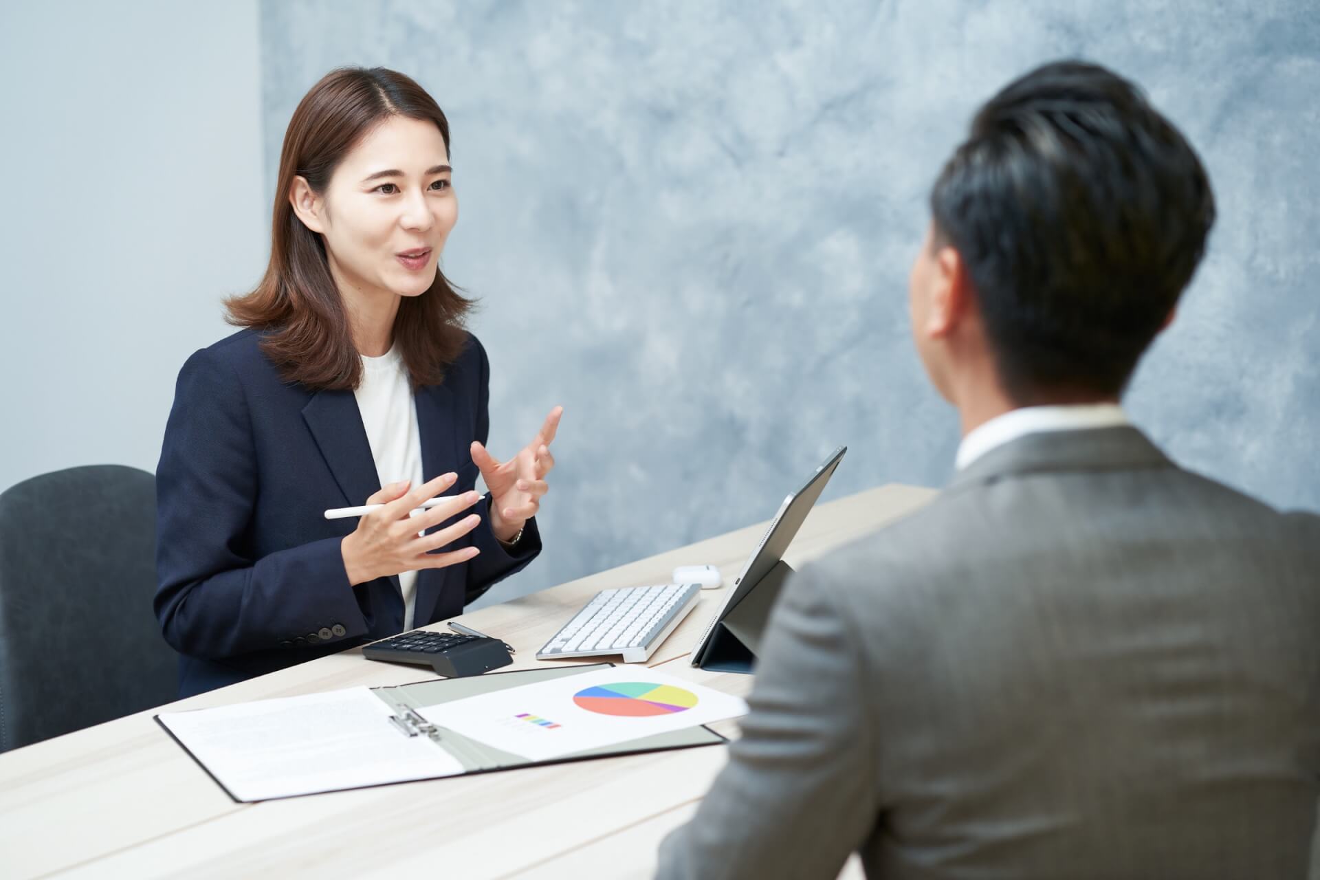 資料を前に提案内容を説明するビジネスウーマン