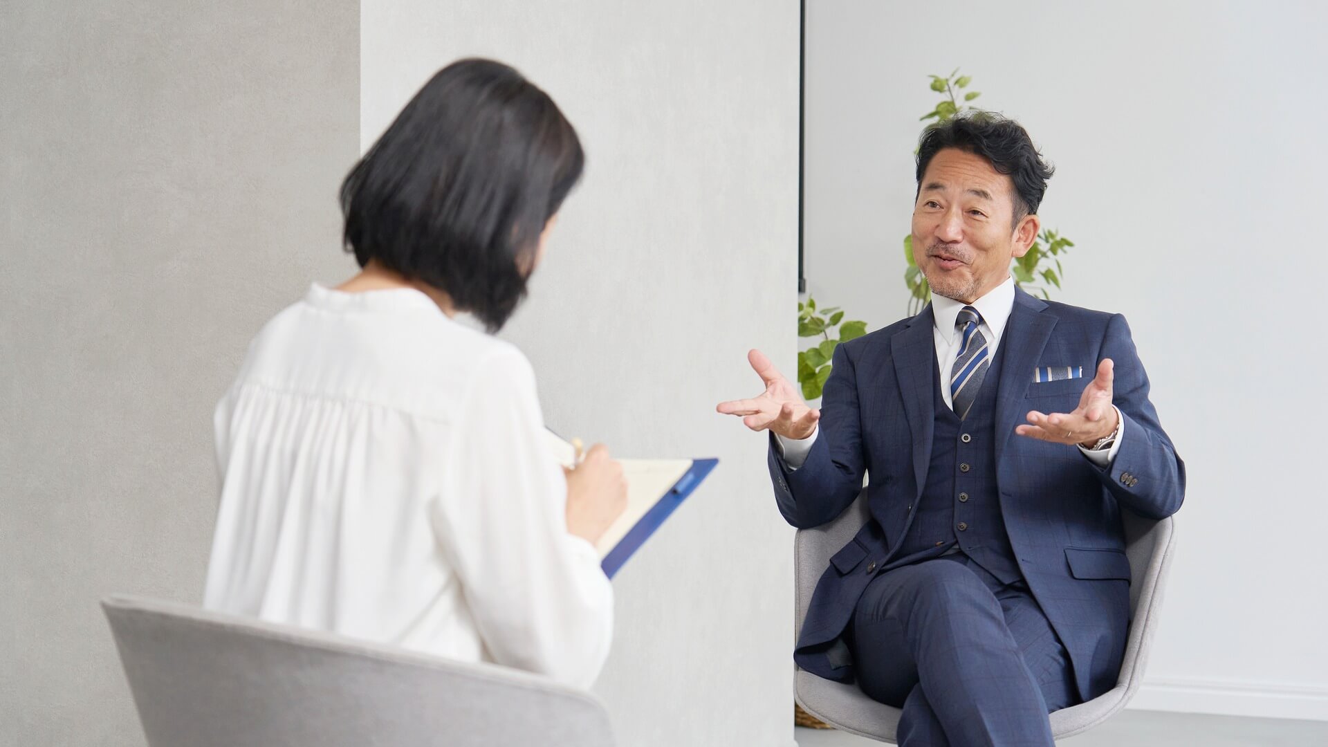 経営者にインタビューする女性インタビュアー
