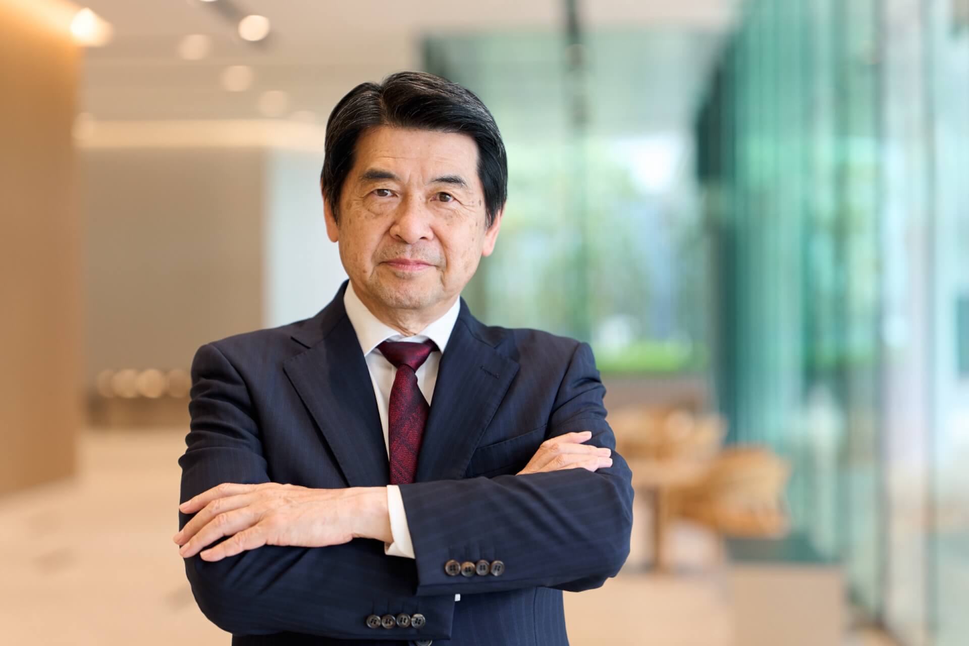 オフィスで腕を組んで立つ経営者