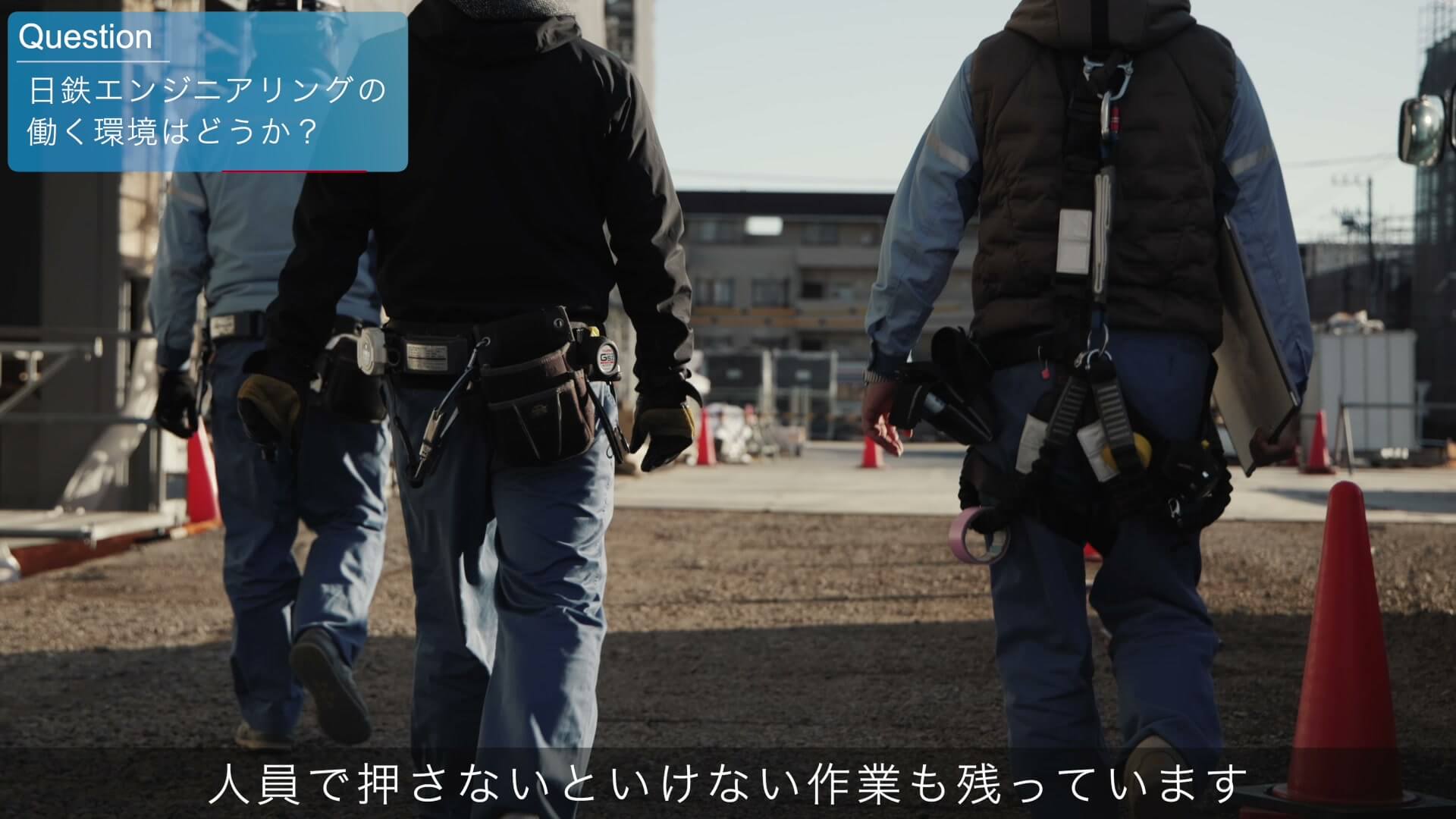 安全帯を着けて現場を歩く施工管理の社員の後ろ姿
