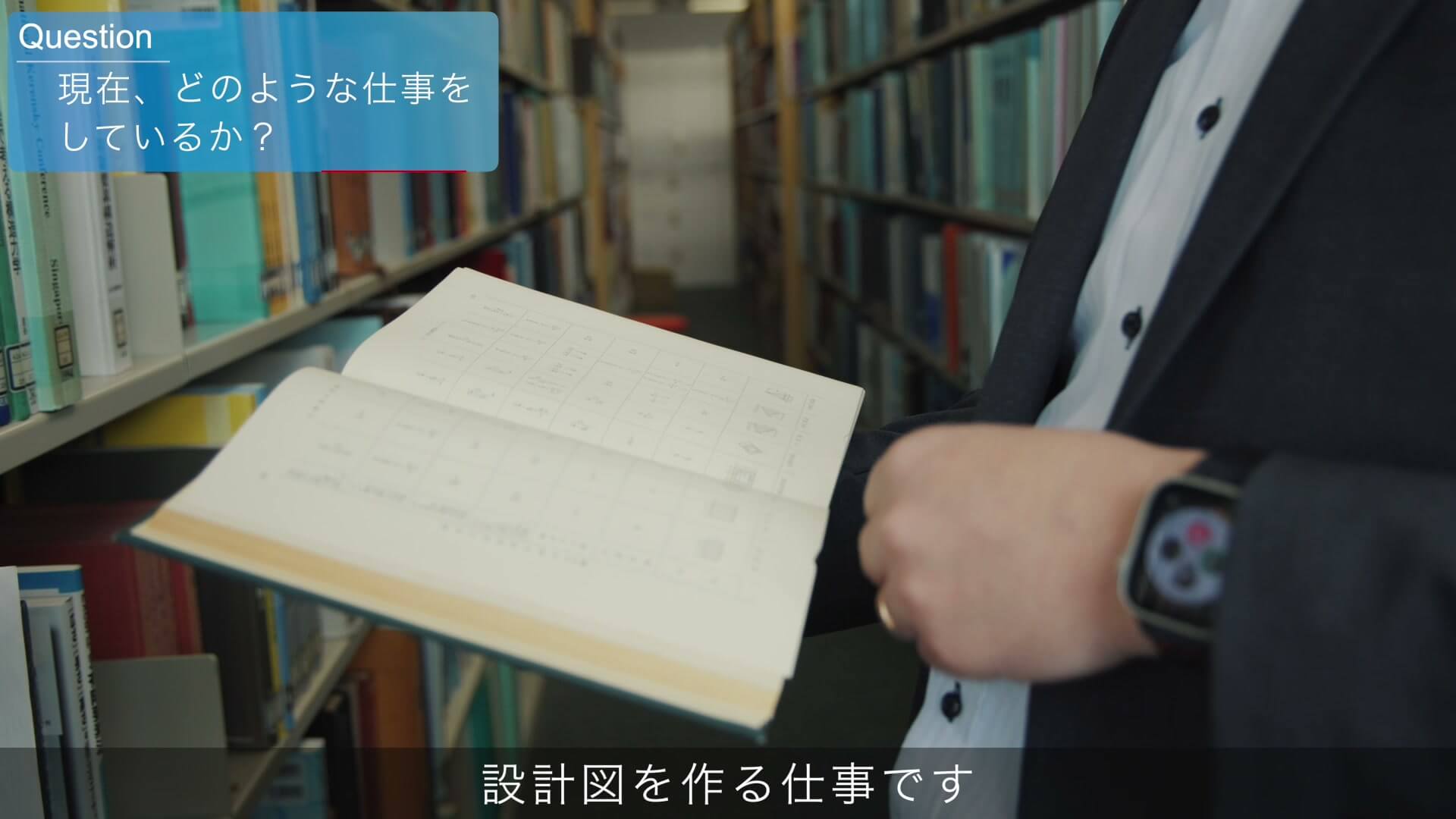 資料室で設計図書のファイルを開く手元