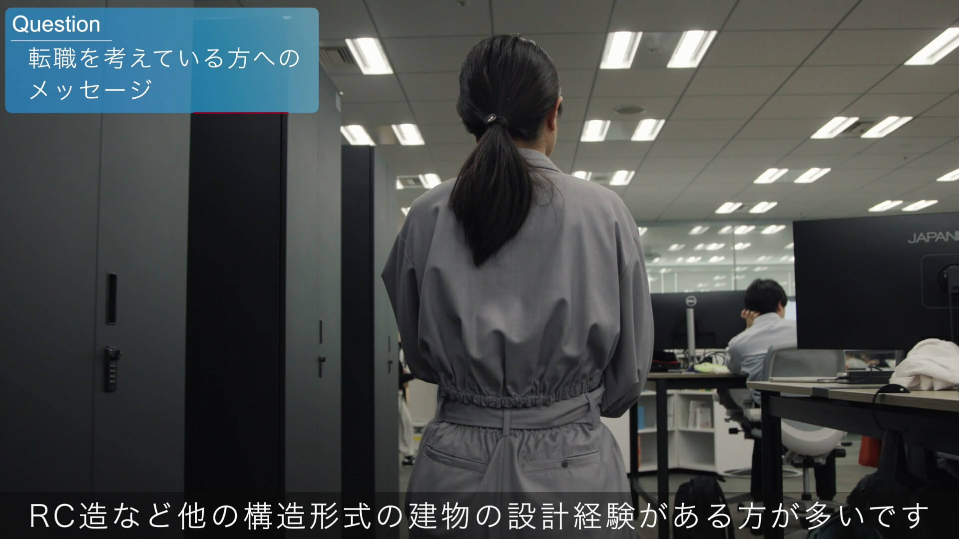 本社オフィスのフロアを歩く社員の後ろ姿