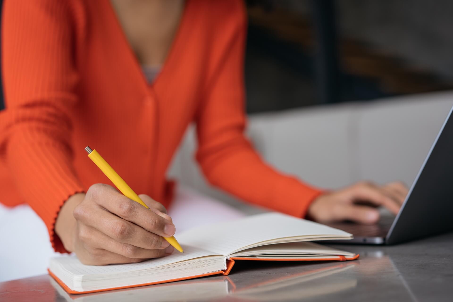 ノートに書き込みながら準備を進める女性