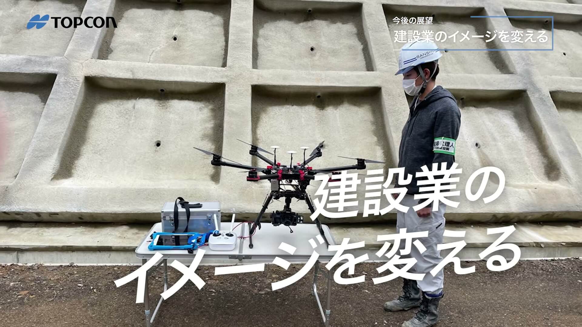 ドローンと擁壁の現場に「建設業のイメージを変える」のテロップ