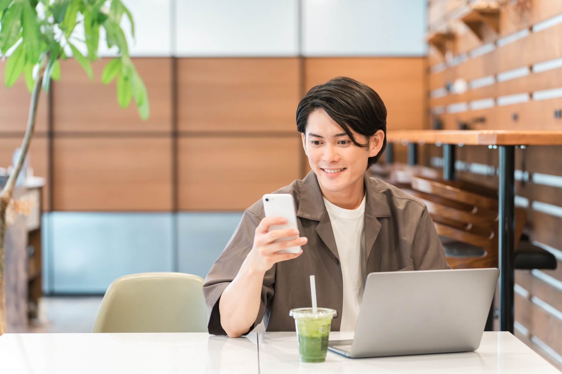 スマートフォンとノートパソコンを使って学習する若手社員