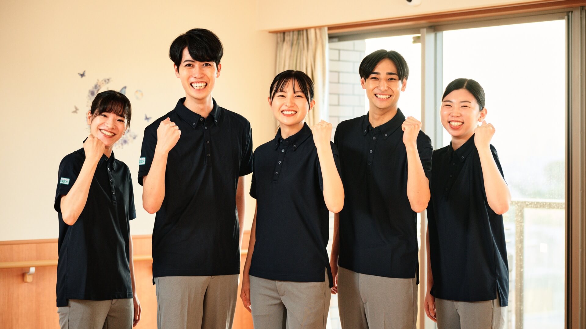 新しいユニフォームを着たスタッフ5人の集合カット