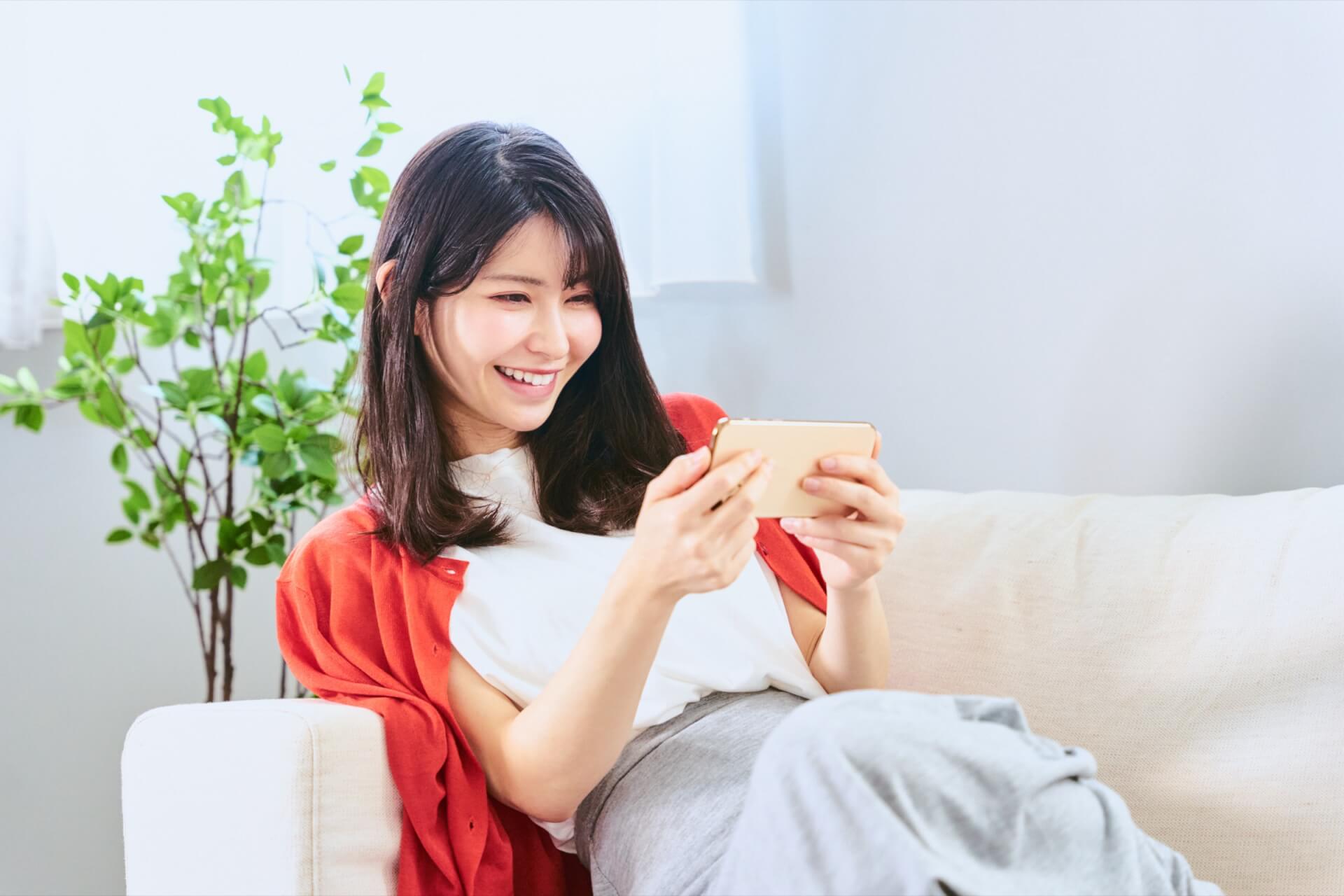 スマートフォンを横向きにして動画を楽しむ女性